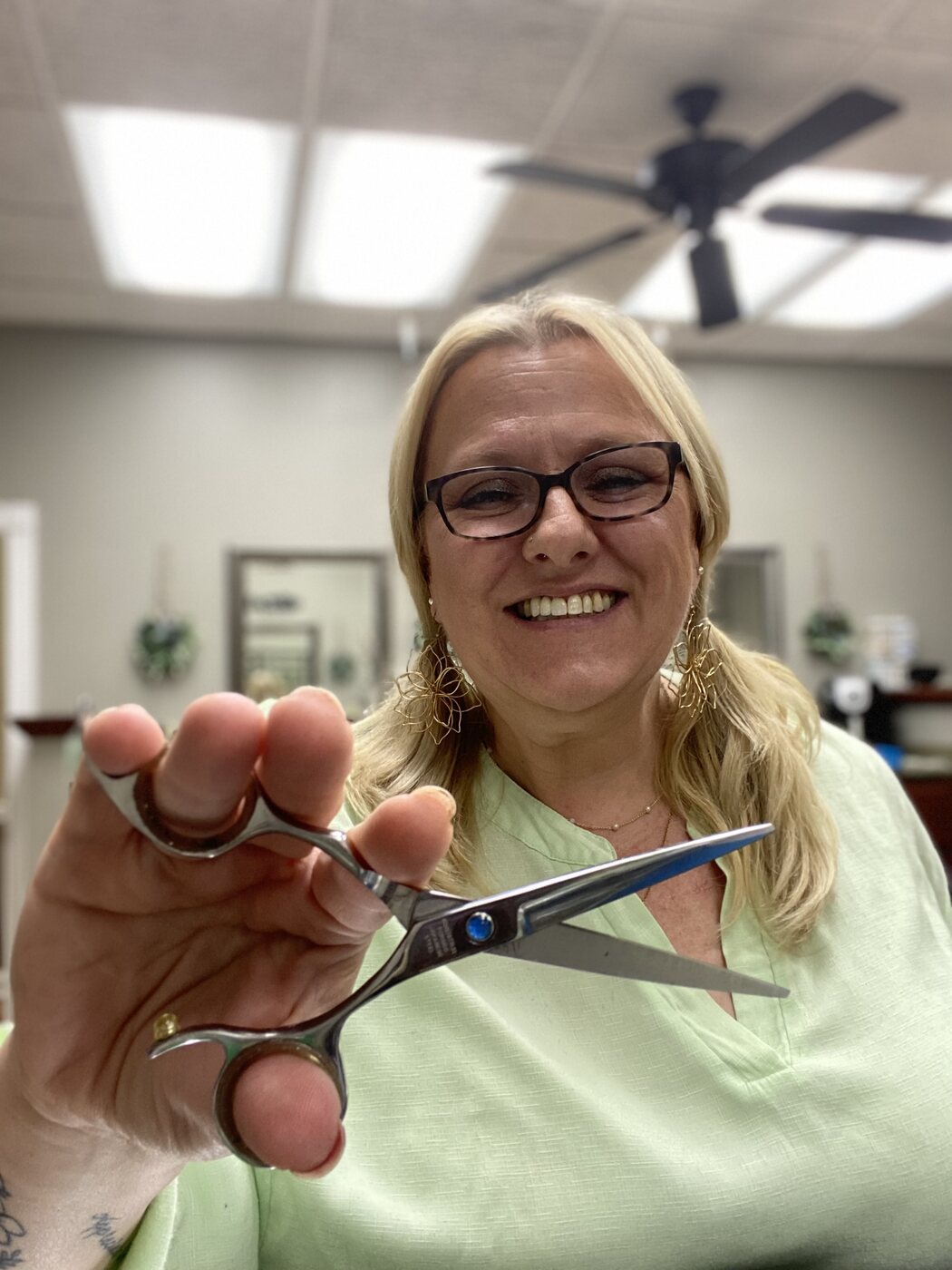 Amy smiling with her professional shears in the salon