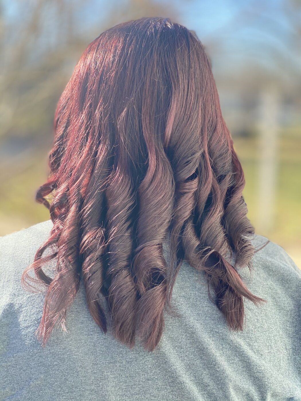 Rich auburn color styled in glossy waves