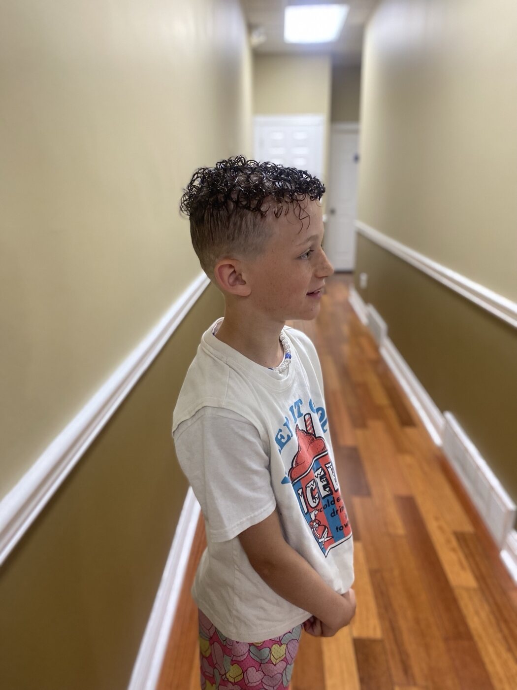 Boy's haircut with a curly top and close fade