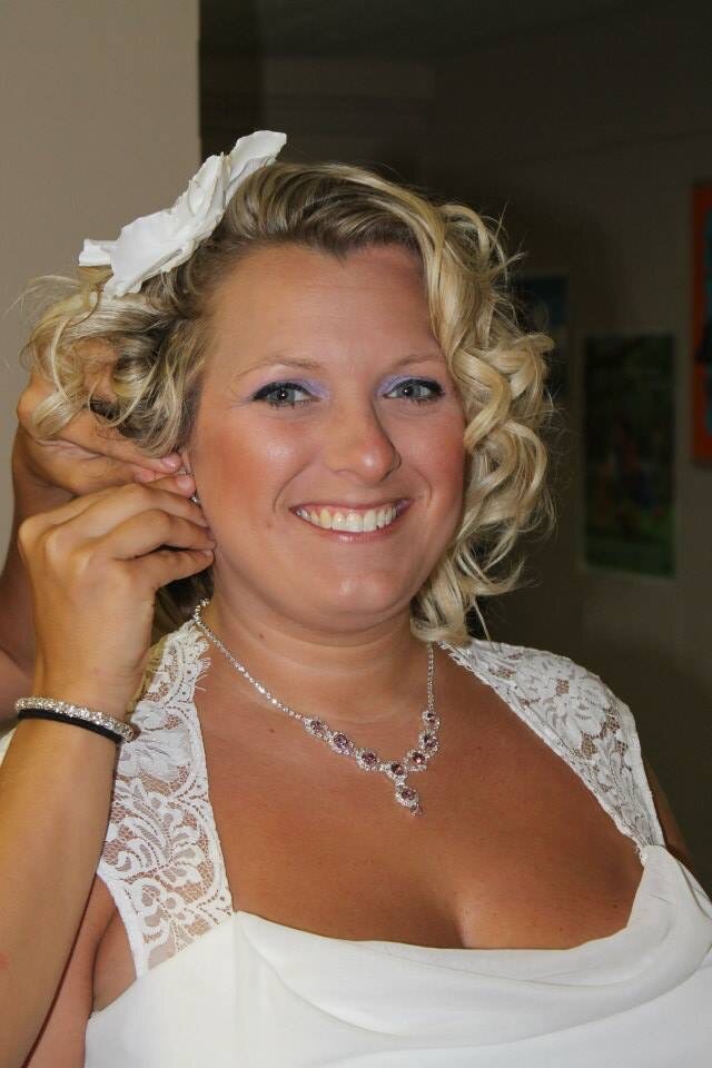 Short blonde hair styled in defined curls for a wedding