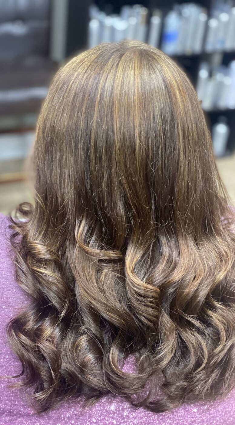 Brunette highlights finished in polished curls