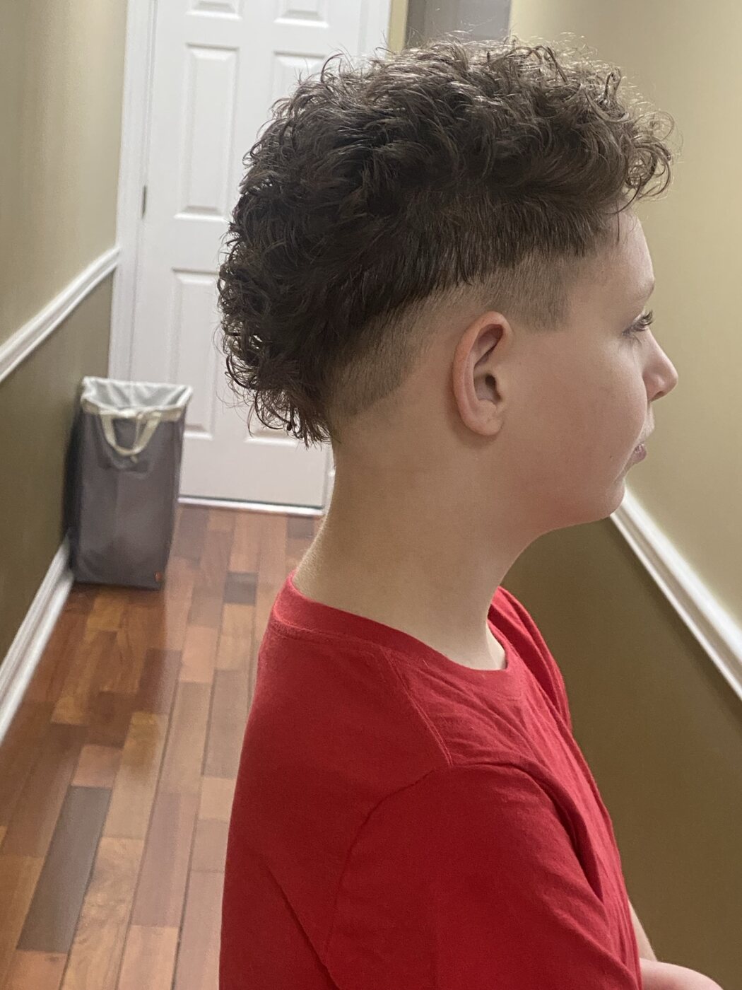 Curly fade haircut with a textured top and crisp side blend