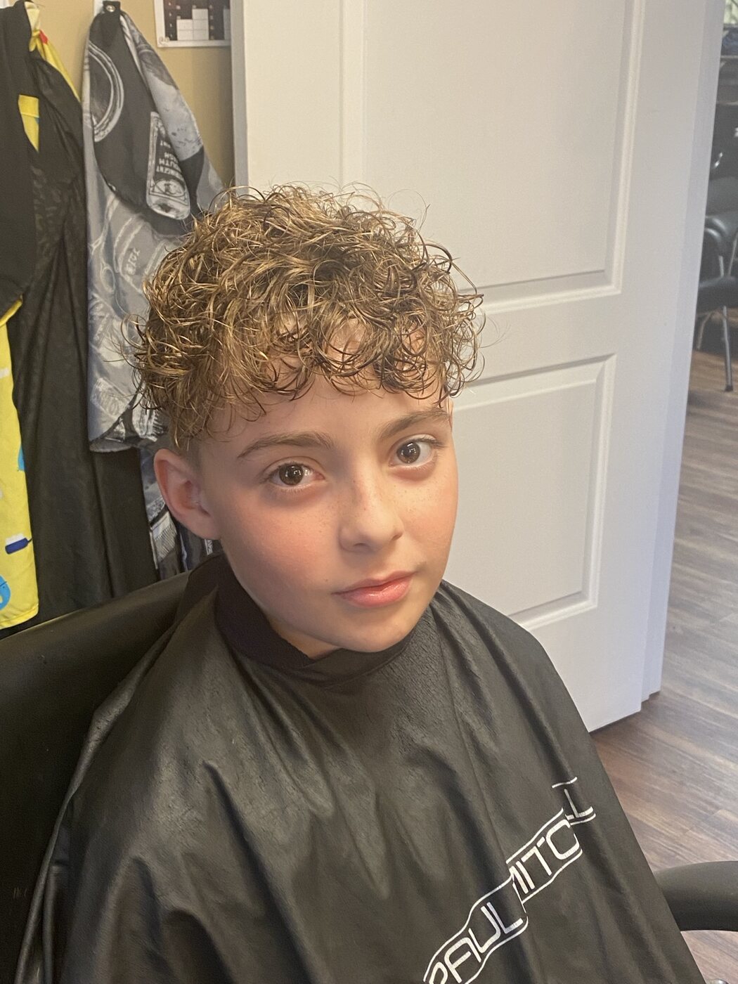 Youth haircut styled to define natural curls