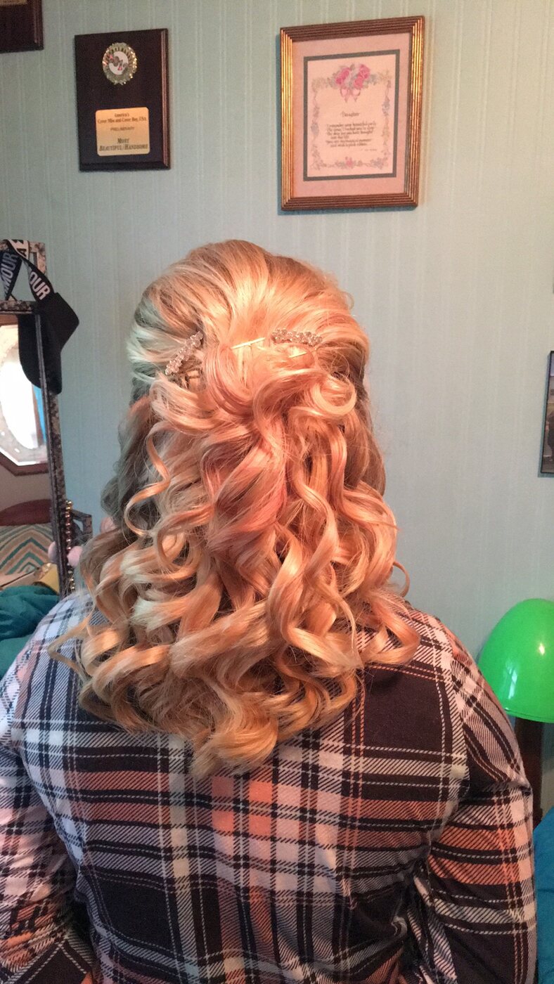 Long blonde hair styled in formal curls and a half-up twist