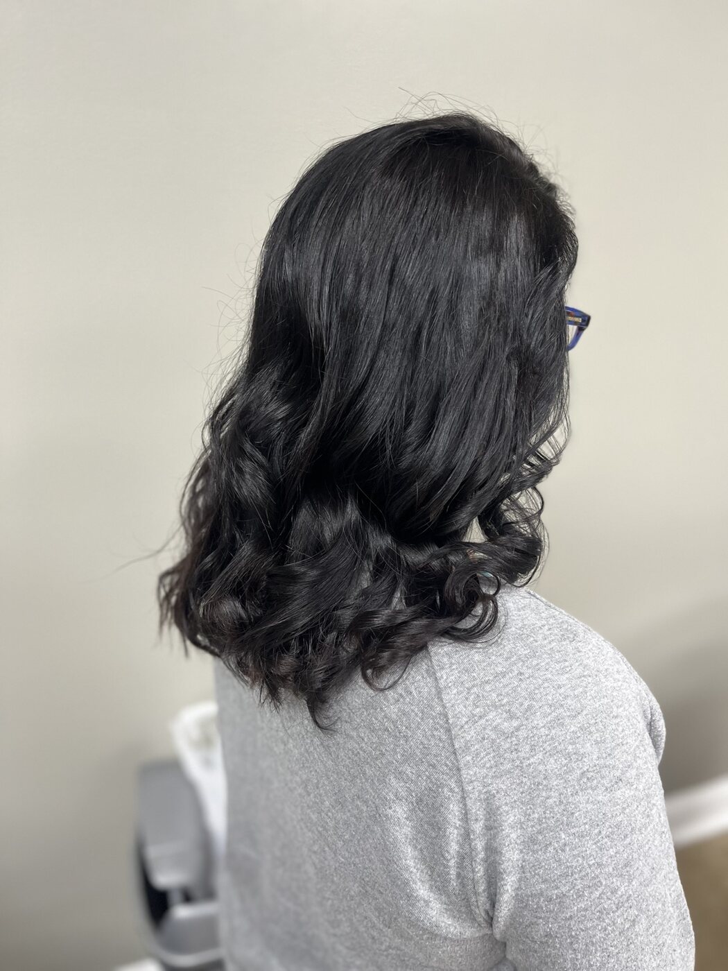 Glossy black hair styled in soft curls