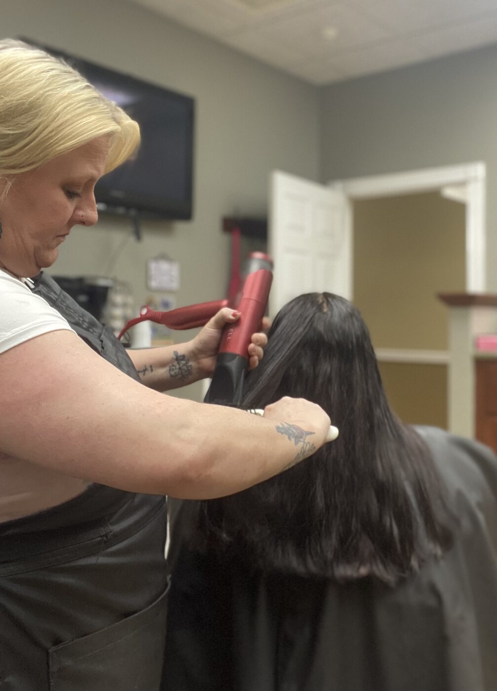 Long black hair being finished during a styling service