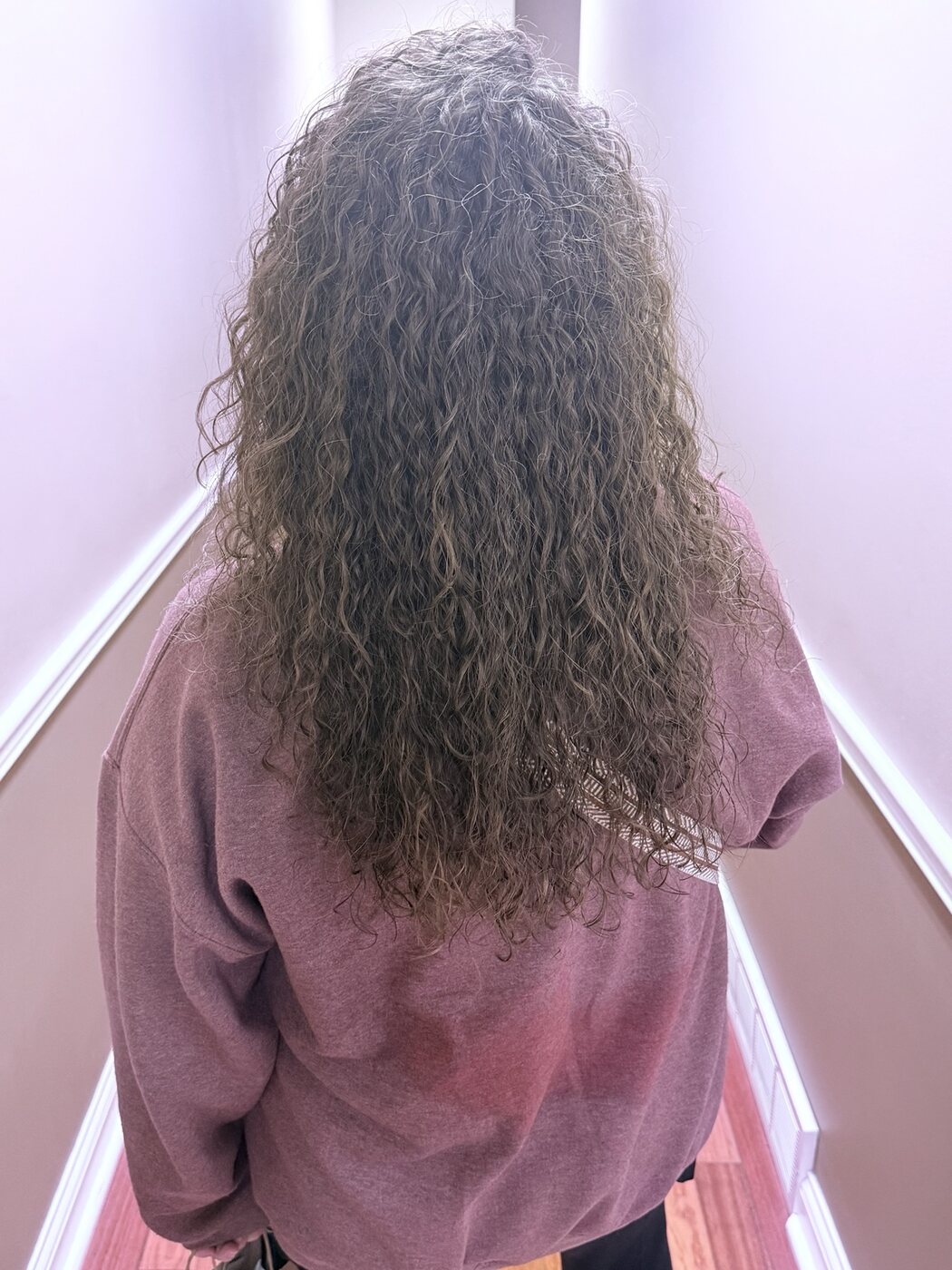 Long dark hair finished with a defined curl pattern