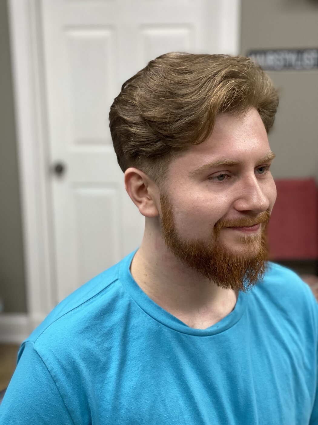Men's haircut styled with volume and a clean taper