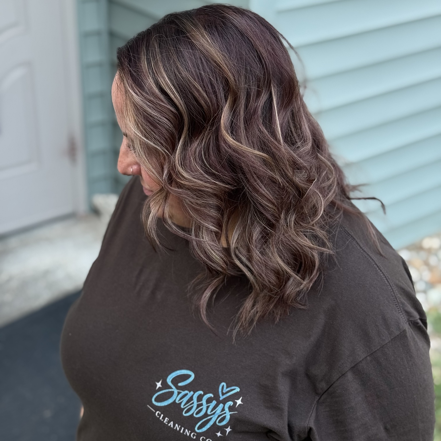 Glossy plum brunette color with face-framing highlights and soft waves