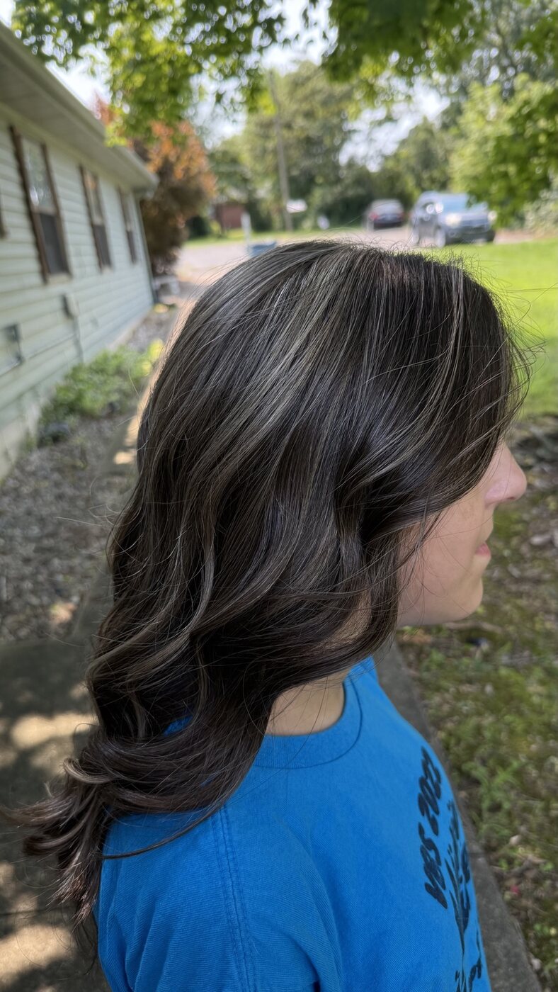 Long brunette hair styled in polished flowing waves