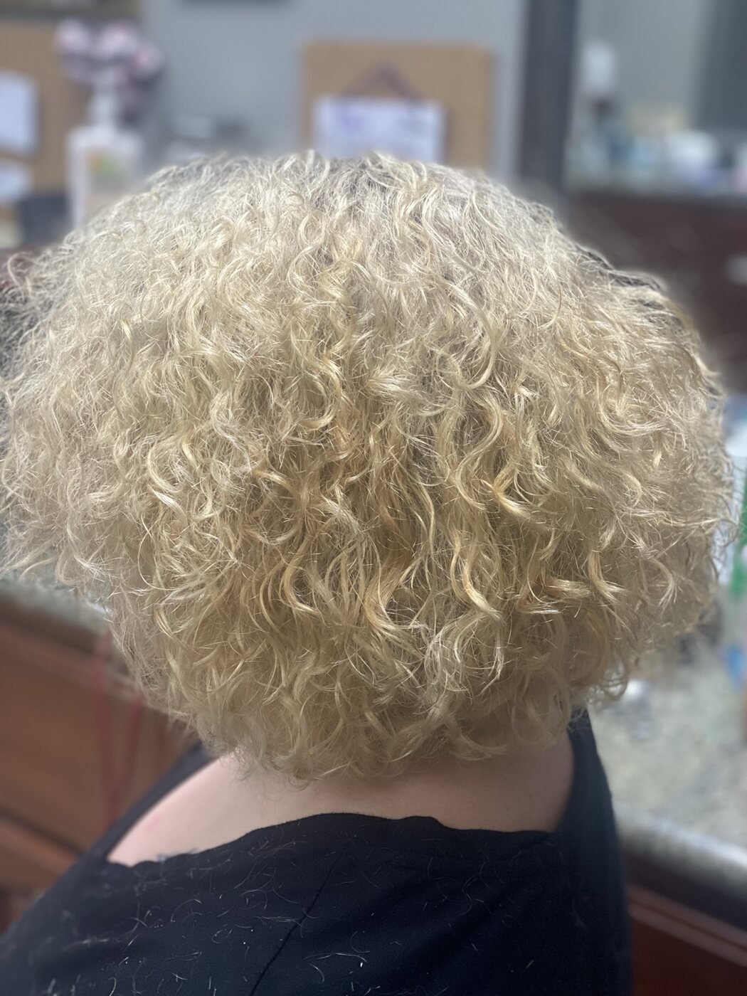 Short blonde hair styled in defined curls