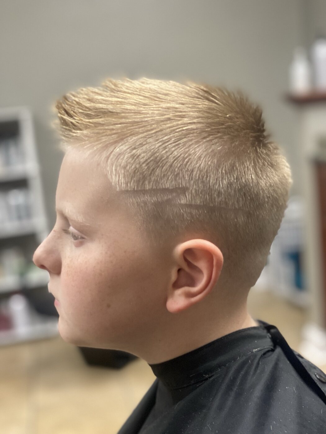 Youth haircut with a blended side fade and styled top